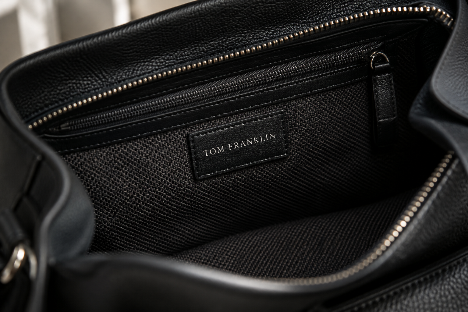 Tom Franklin stamp inside a black handbag